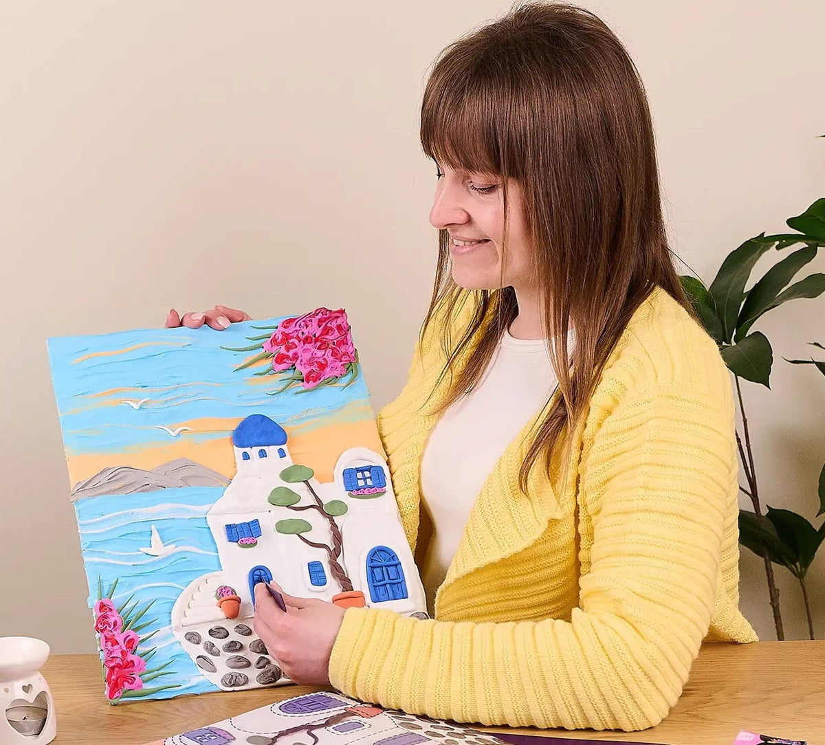 Woman holding a finished Santorini 3D clay painting